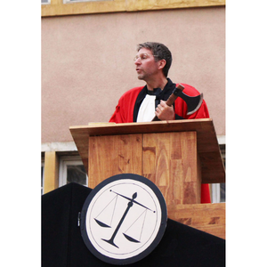 Un juge à son pupitre avec une hache