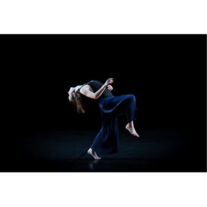 Une femme qui dansent habillée en noir et bleu sur un fond noir