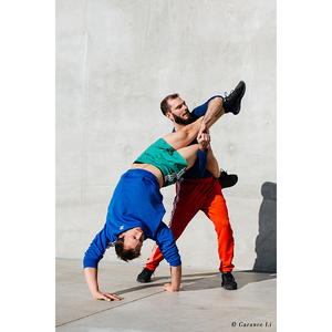 Un homme qui porte un autre qui fait un poirier