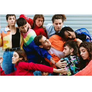 Des hommes et des femmes habillés en couleurs qui se serrent les uns contre les autres