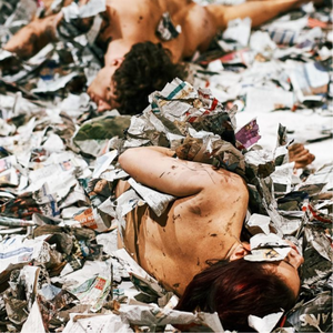 2 personnes nues dans un tas de papiers journaux