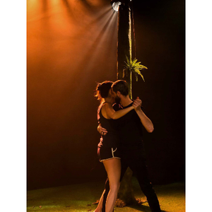 un couple danse un slow sous une lumière jaune