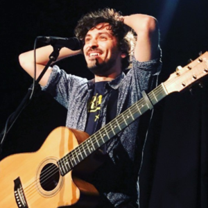 Sèbe sur scène avec guitare acoustique