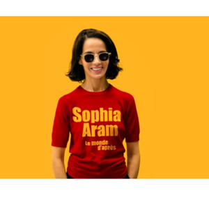 Sophia Aram en lunettes de soleil et tee shit rouge avec écrit "Sophia Aram, le monde d'après" dessus